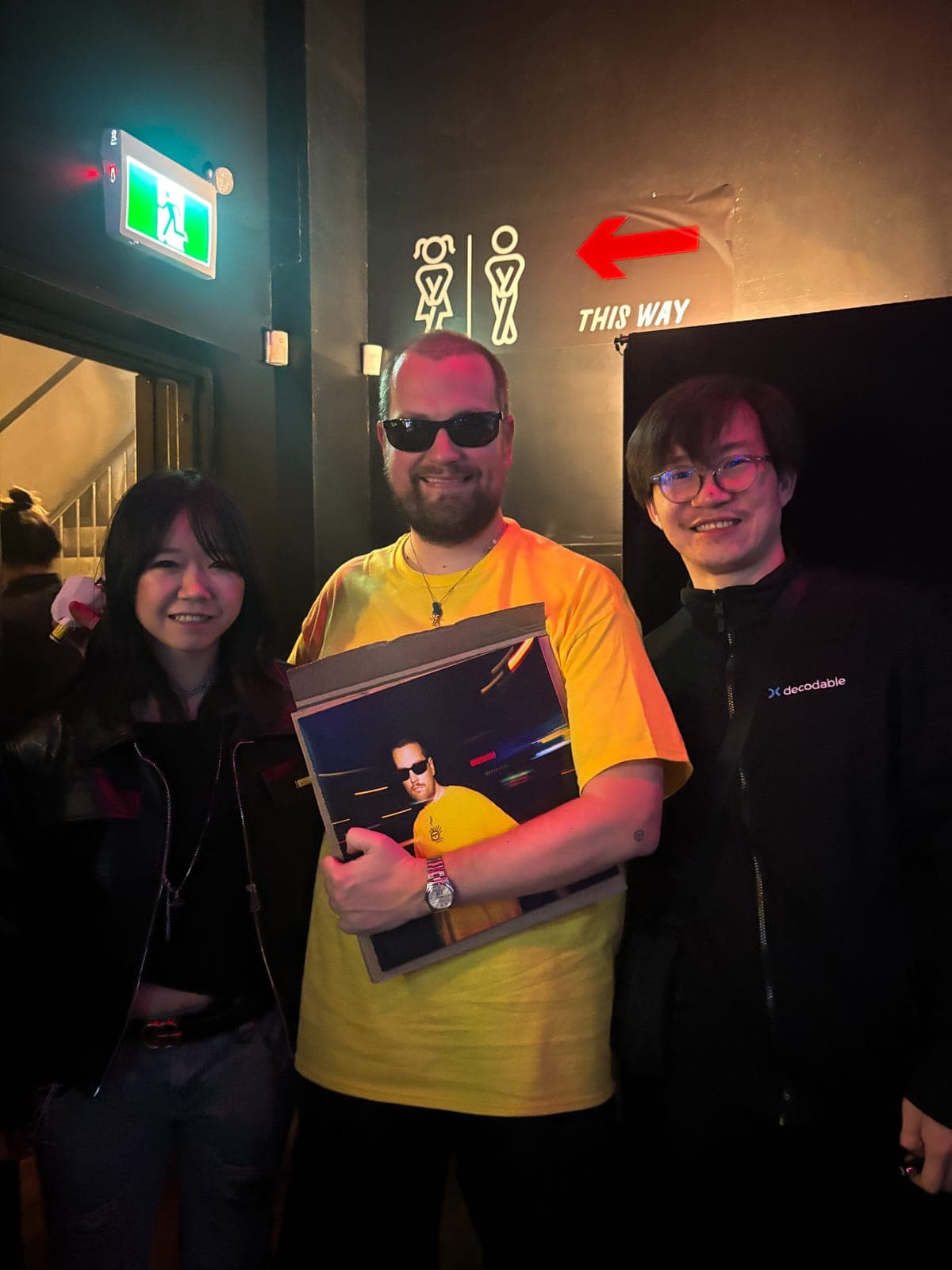 Myd posing with fans after the show at the Mod Club, holding a signed print of himself in his yellow t-shirt