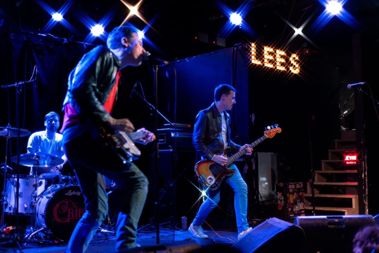 The Cribs mid-set at Lee's Palace, Toronto - Ryan Jarman blurred in motion on guitar in the foreground while Gary Jarman holds a sunburst Precision bass in sharp focus under the 'LEES' sign
