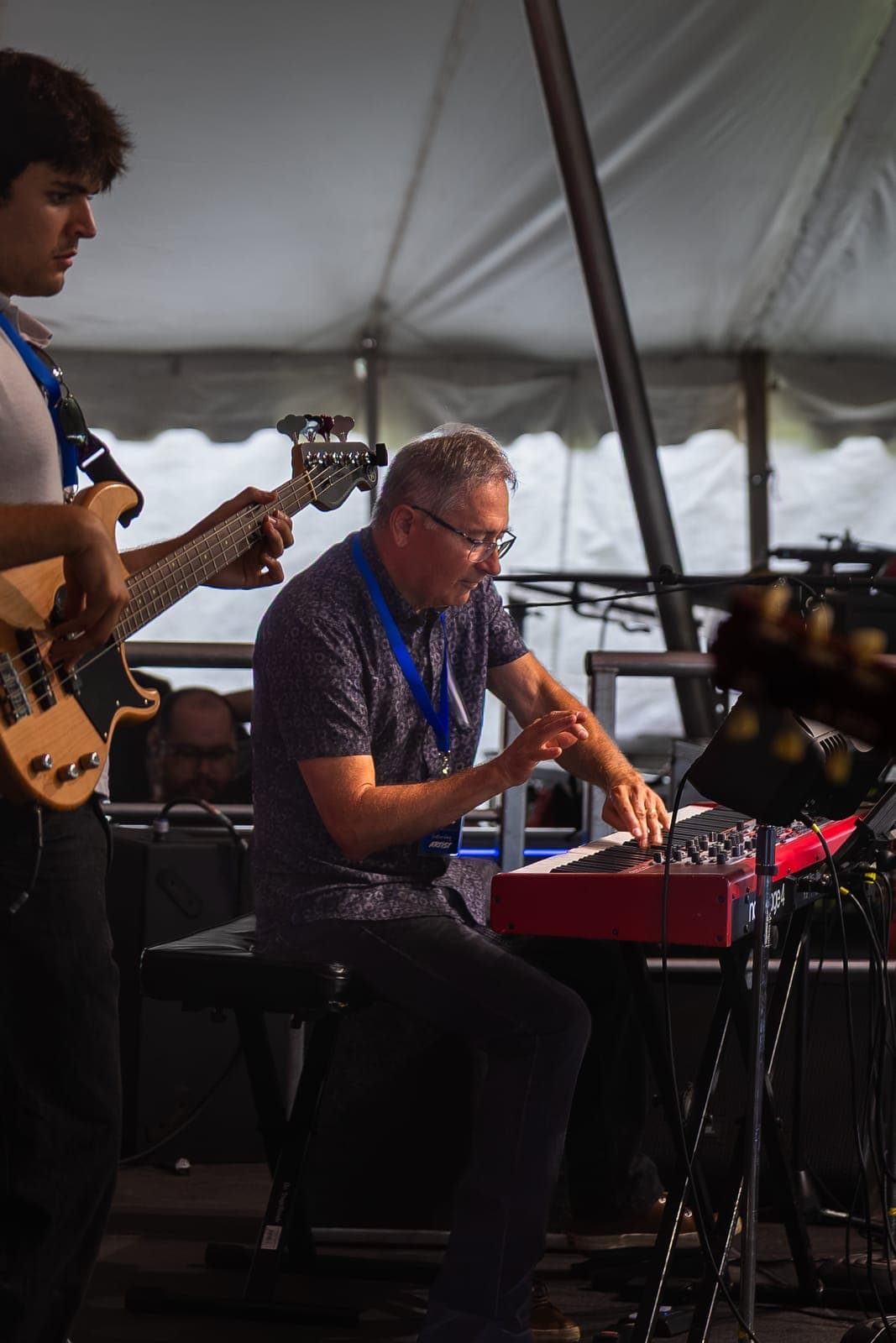 Isy Aboagye's bassist plays on the left while the keyboardist works his red Nord under the daylit festival tent at Kitchener Blues Festival