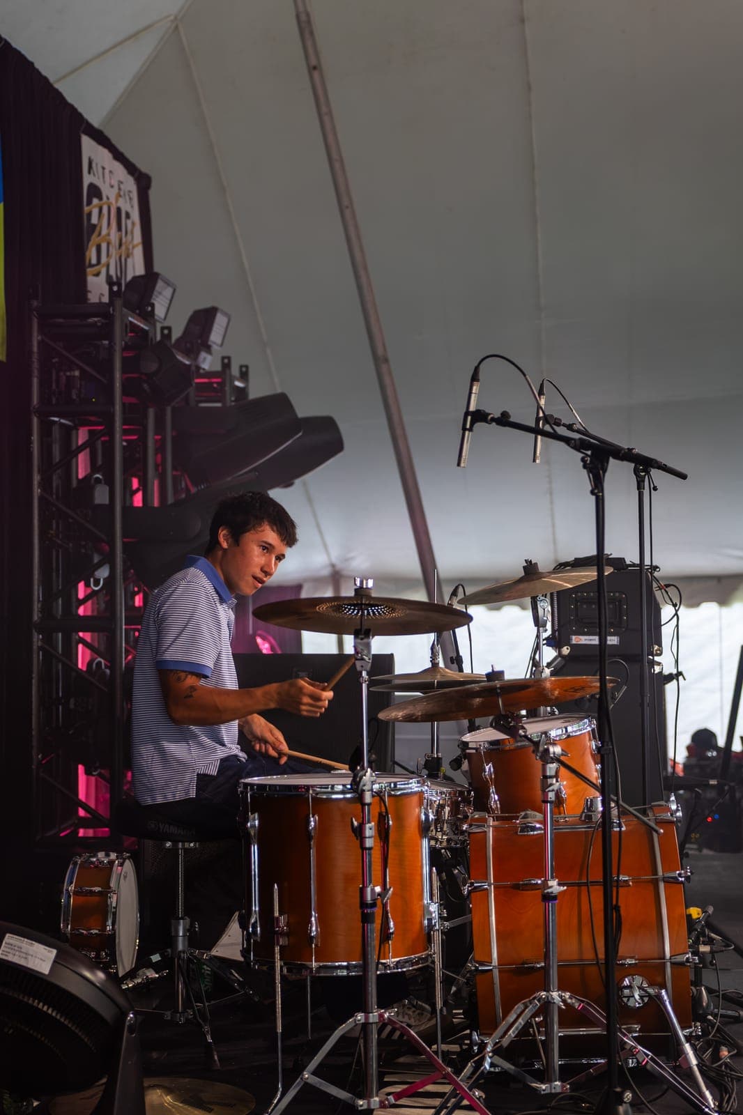 Isy Aboagye's drummer, in a striped polo, looks up mid-fill behind his Yamaha kit at Kitchener Blues Festival