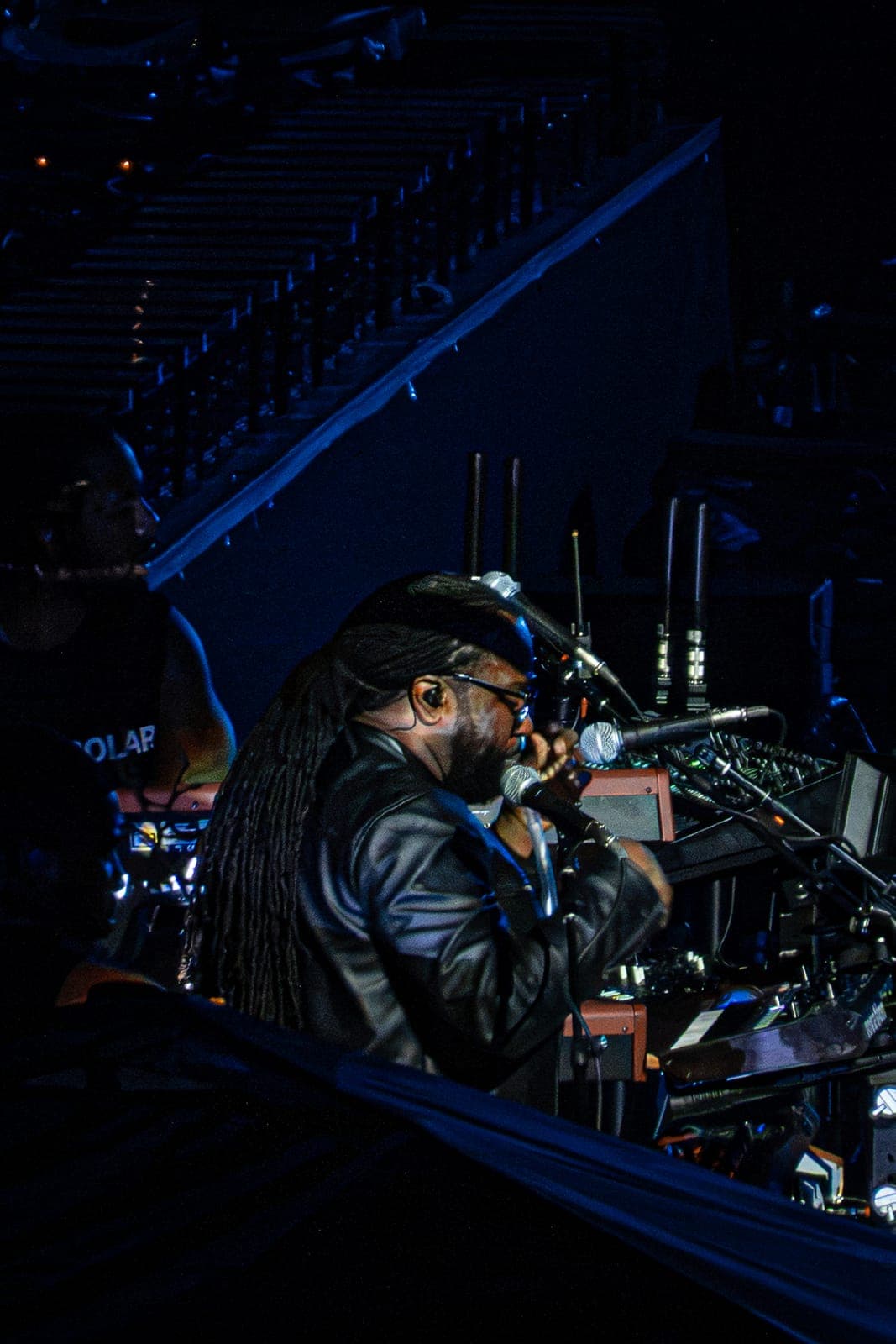 André Troutman works his talk box at the side of the stage, the tube held to his mouth in front of the mic, long locs spilling over his black leather jacket as he plays his keyboard rig