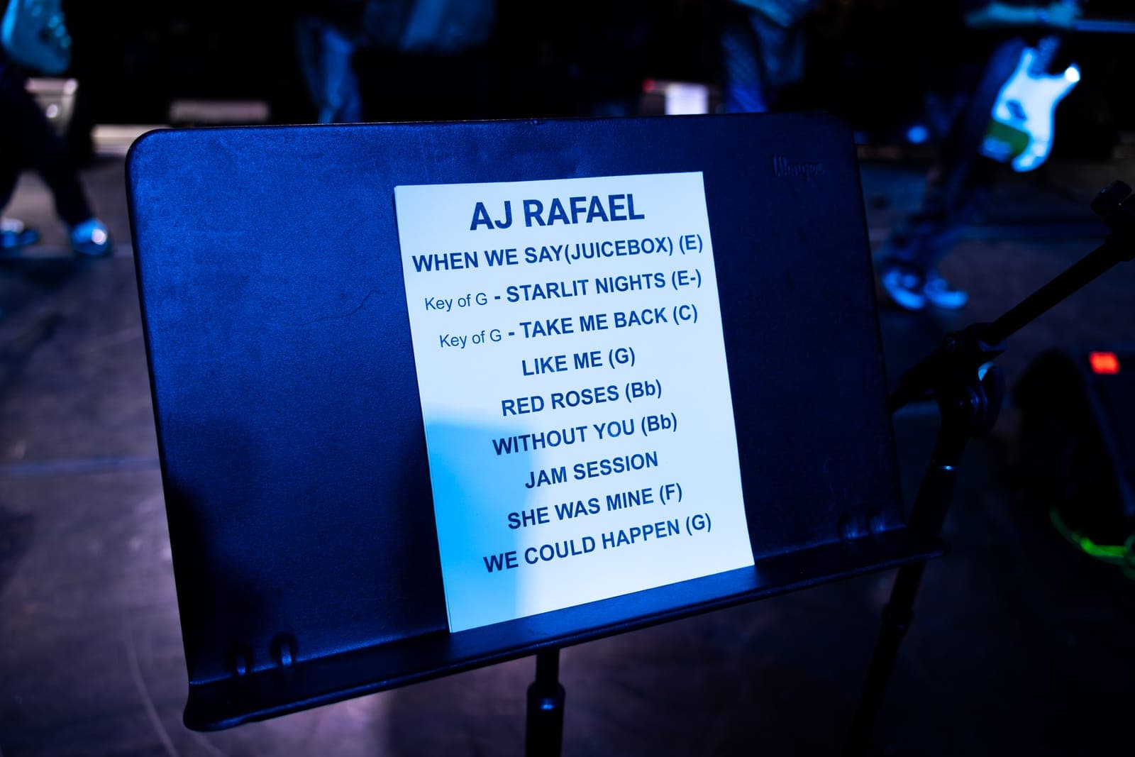AJ Rafael's handwritten setlist on a music stand, opening with 'When We Say (Juicebox)' and running through 'Take Me Back', 'Red Roses' and 'We Could Happen'