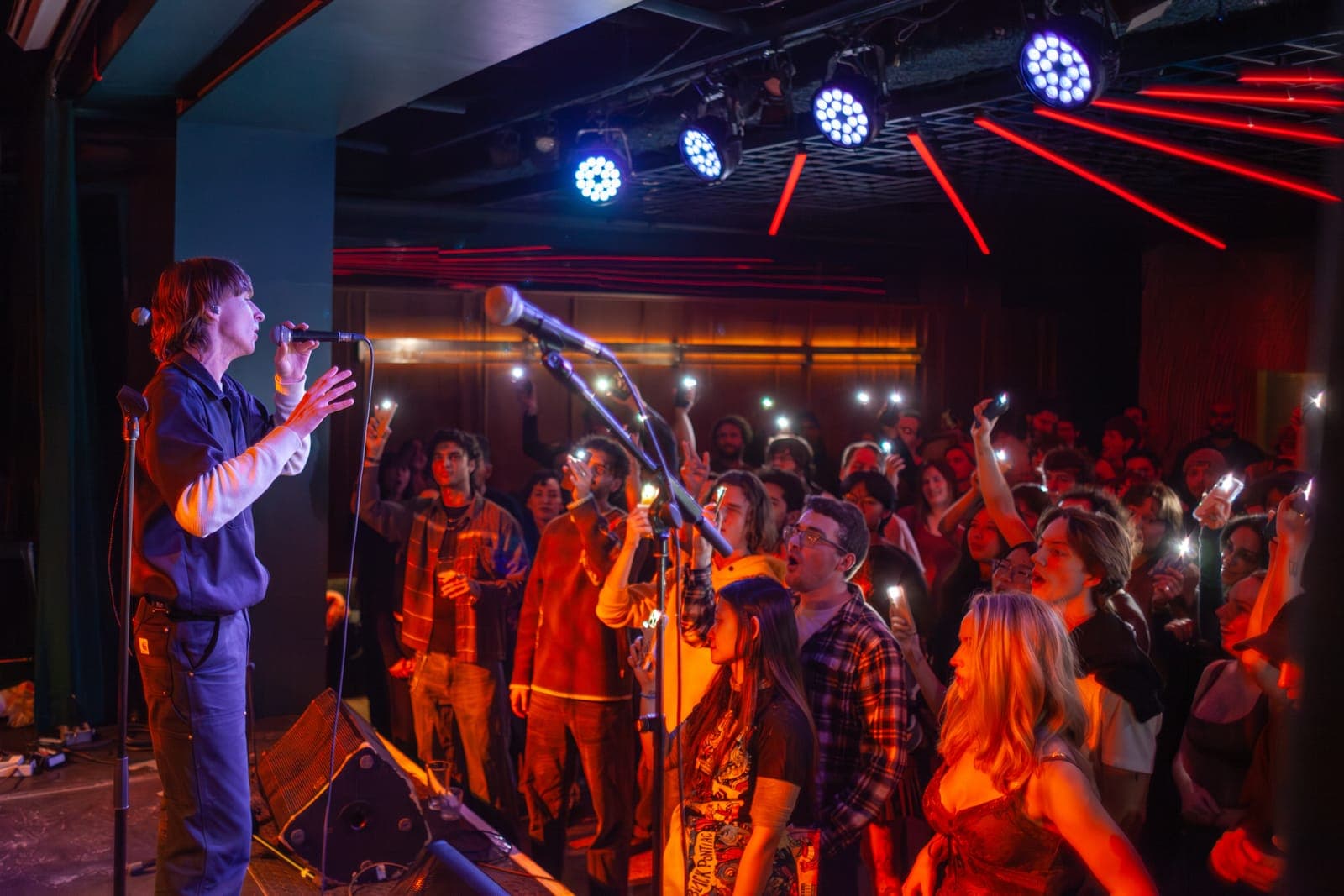 Black Pontiac's singer at the mic on stage left while the crowd raises phone flashlights at The Drake Underground, Toronto