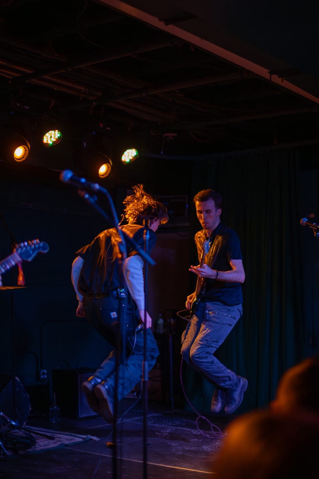 Two members of Black Pontiac leap mid-air in unison during an energetic set at The Drake Underground, Toronto
