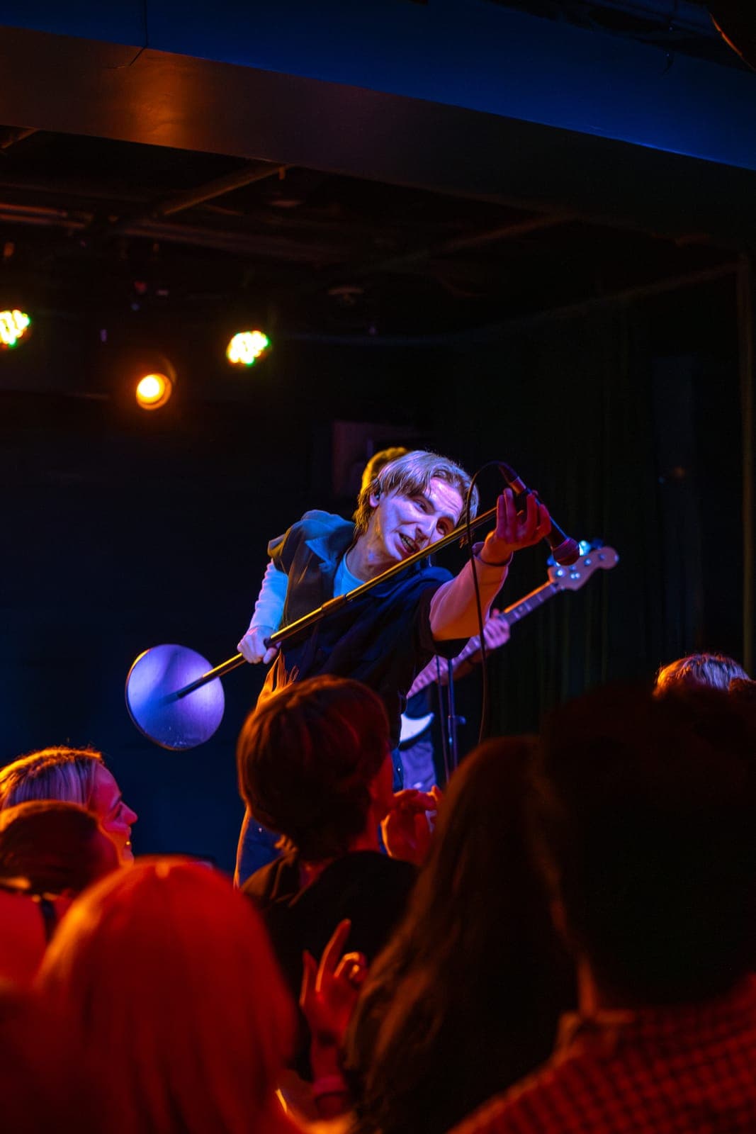 Black Pontiac's singer leans off the stage into the crowd with the mic stand extended at The Drake Underground in Toronto