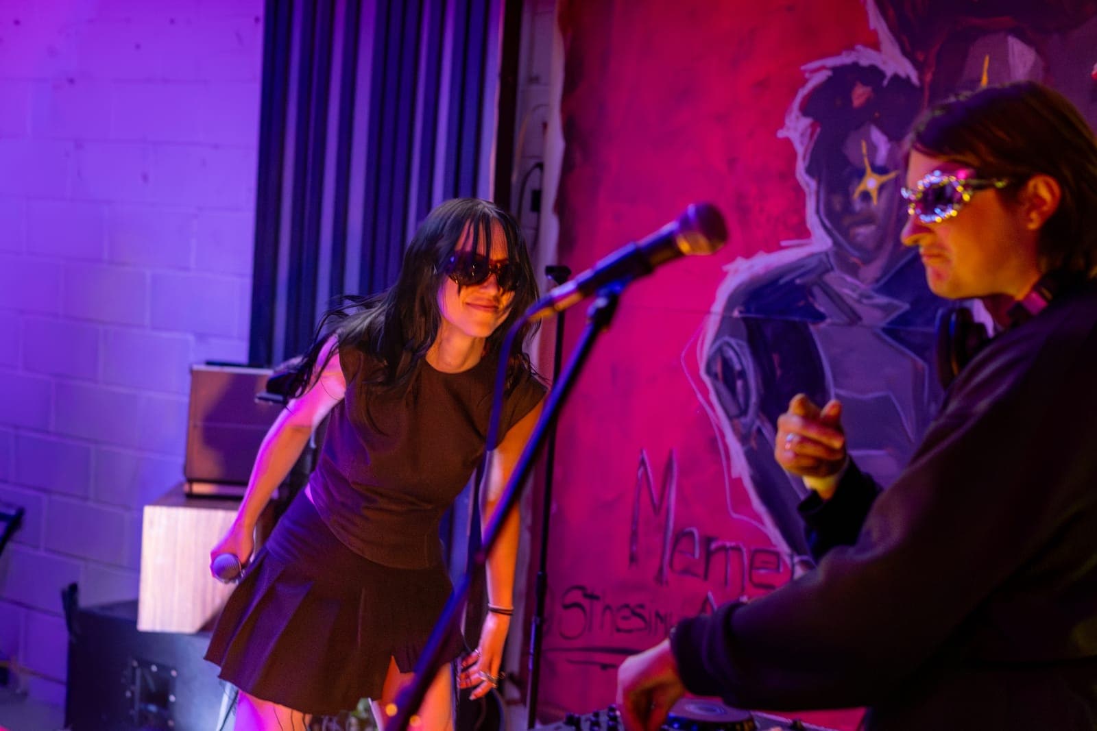 City Builders' vocalist dances beside the mic as the producer works the decks in front of a red mural at Division 88, Toronto