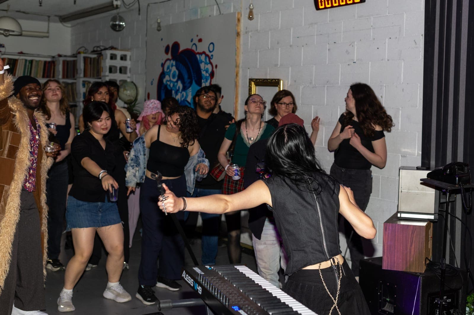 City Builders' vocalist reaches toward the dancing crowd from behind the keyboard at Division 88 in Toronto