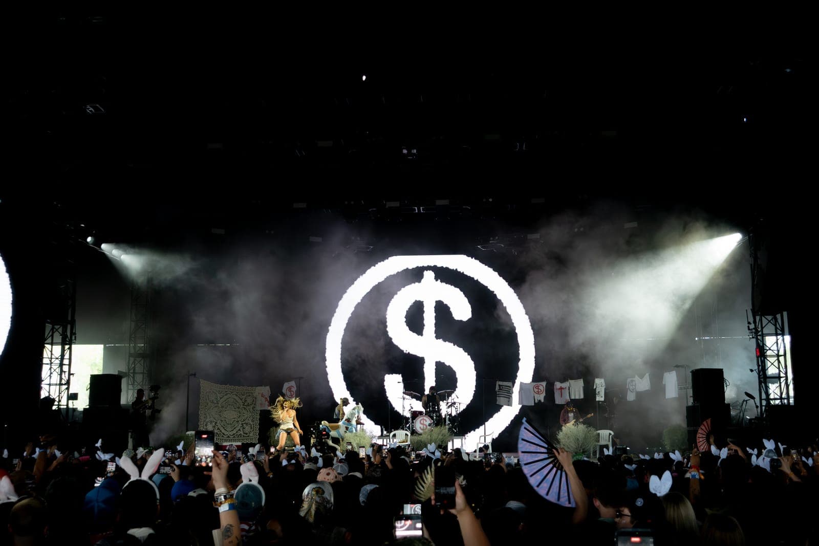 Slayyyter's stage glows with a giant dollar-sign logo over the smoky set at Coachella, Indio