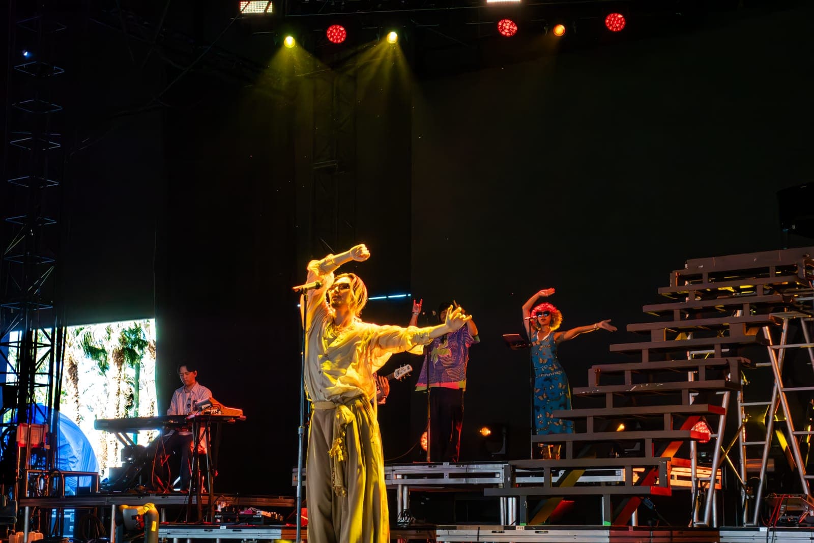 Fujii Kaze sings under a golden spotlight as dancers move behind him at Coachella, Indio