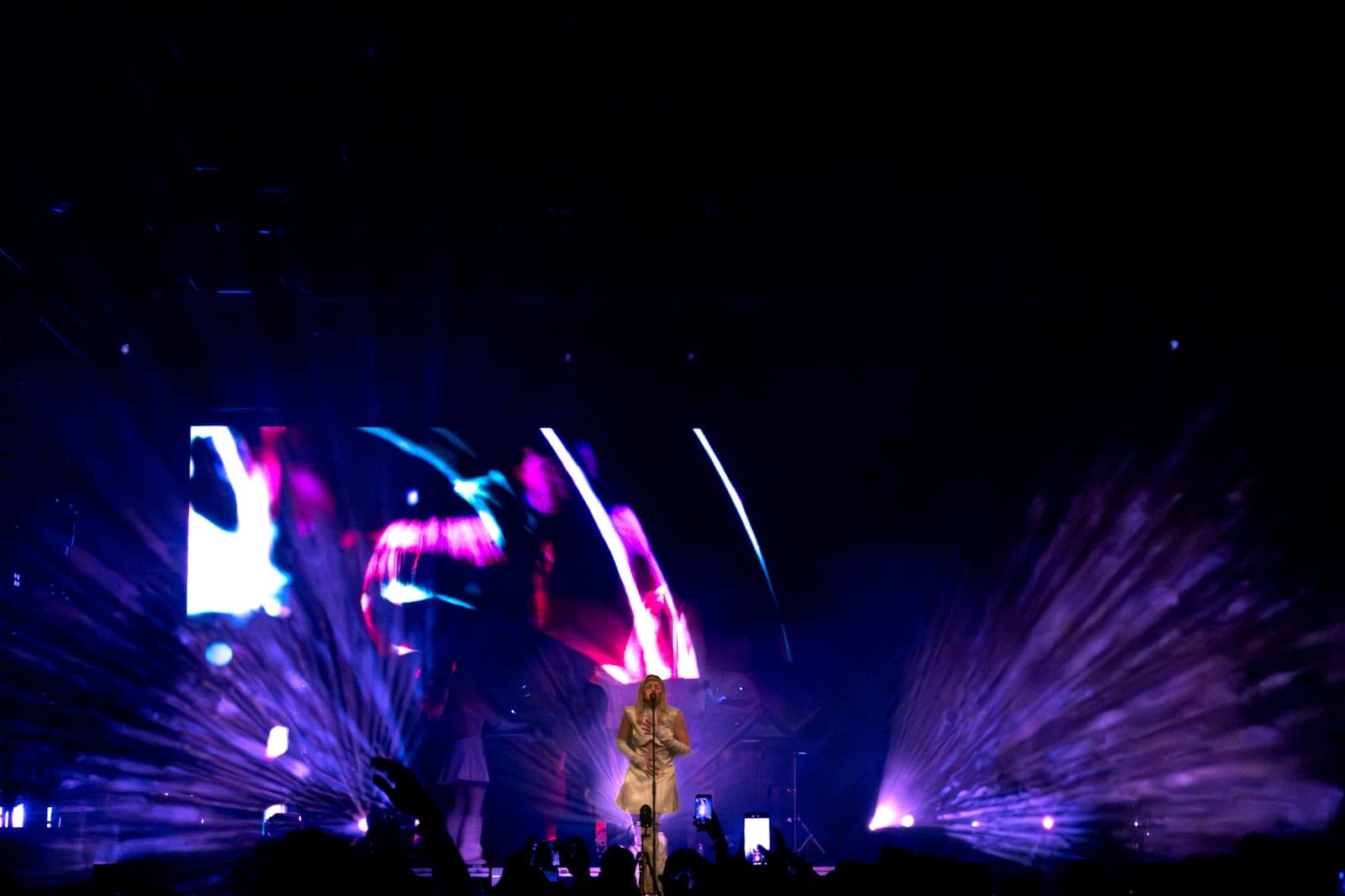 Tomora sings at the mic amid bursting purple light beams at Coachella, Empire Polo Club in Indio
