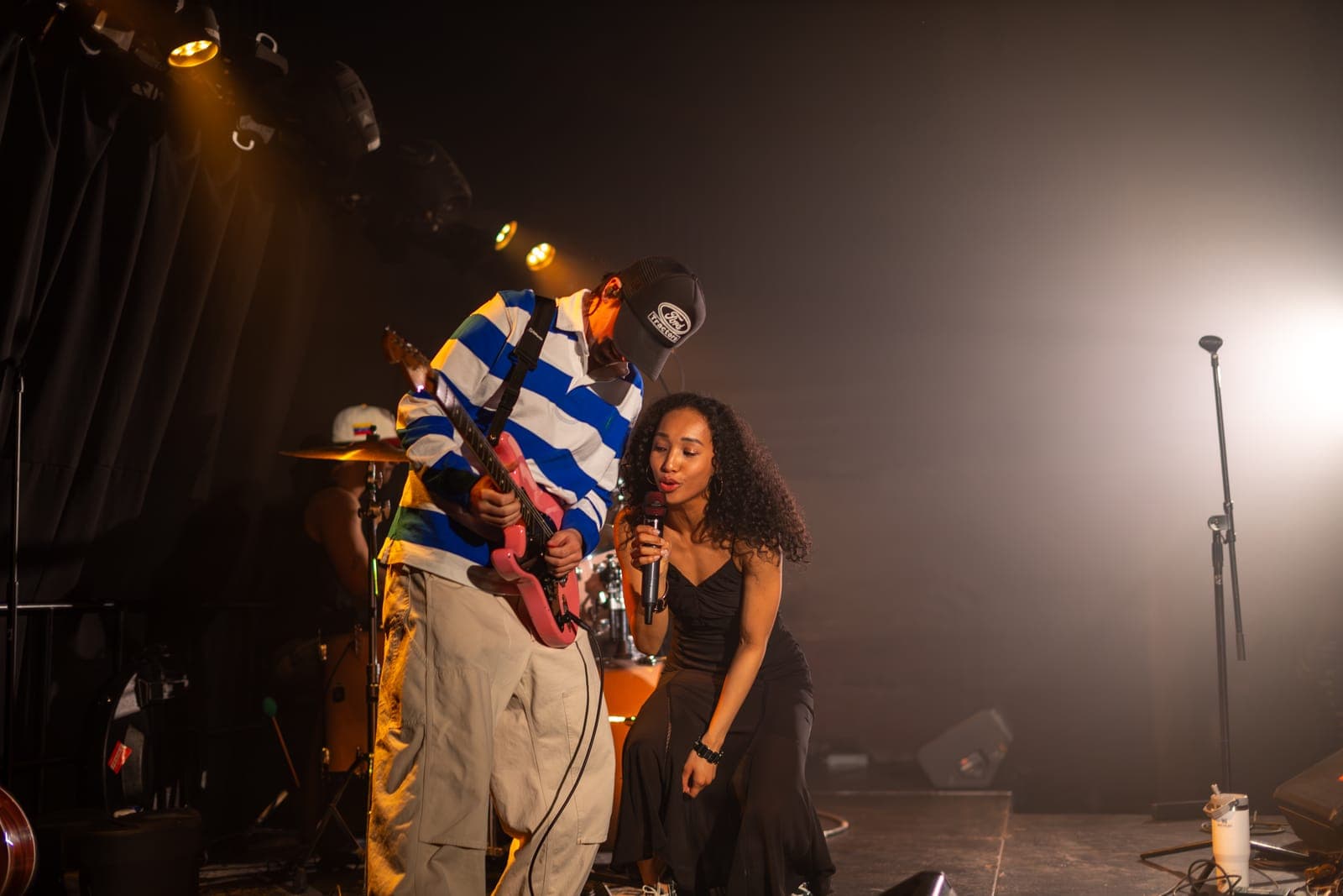 Nia Nadurata crouches singing beside her guitarist during Departure Festival at Longboat Hall in Toronto