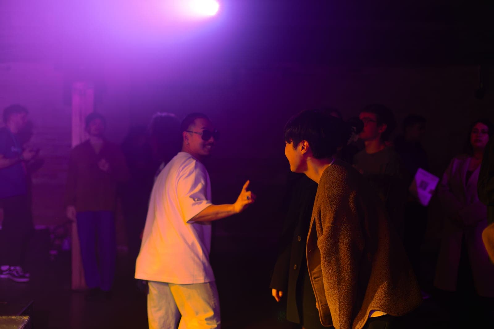 Cherry Kim shares a laugh with a fan in the crowd under a purple haze at Longboat Hall, Toronto