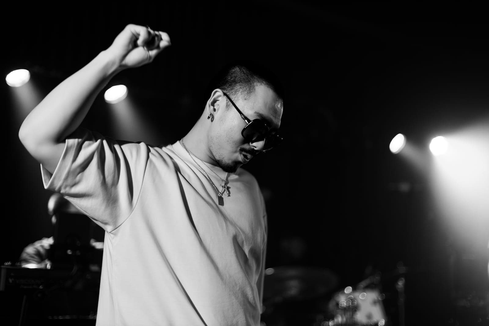 Black-and-white close-up of Cherry Kim mid-flow with a raised fist and sunglasses at Longboat Hall in Toronto