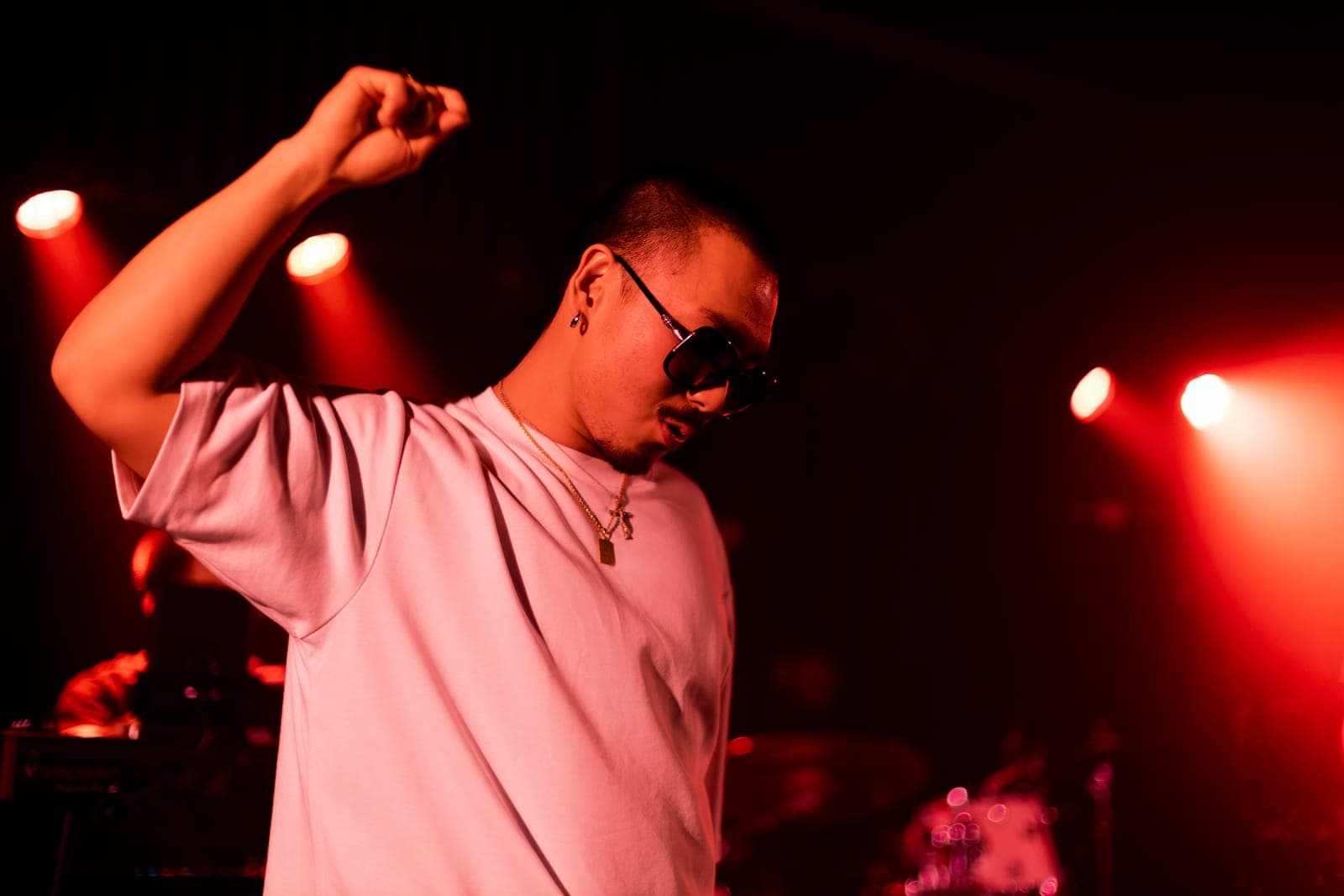 Cherry Kim dances with a raised fist under red light at Longboat Hall in Toronto