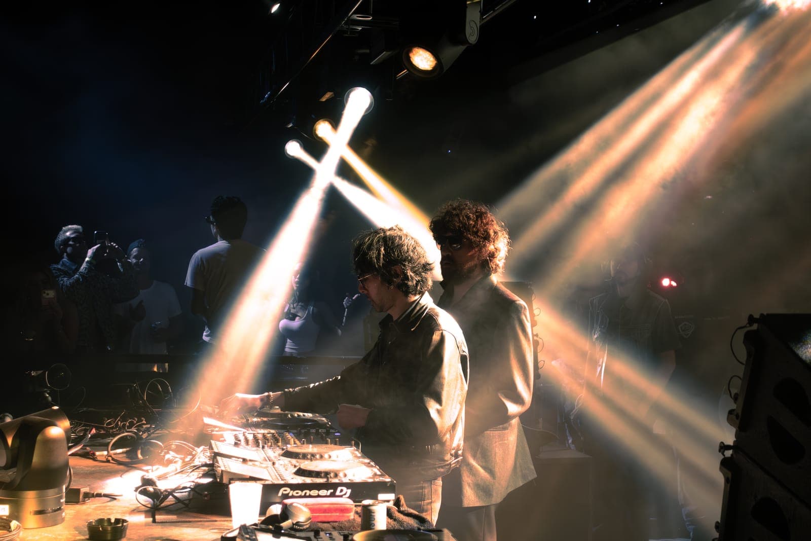 Justice play beneath crossed beams of light at the Pioneer decks during Factory Town in Miami