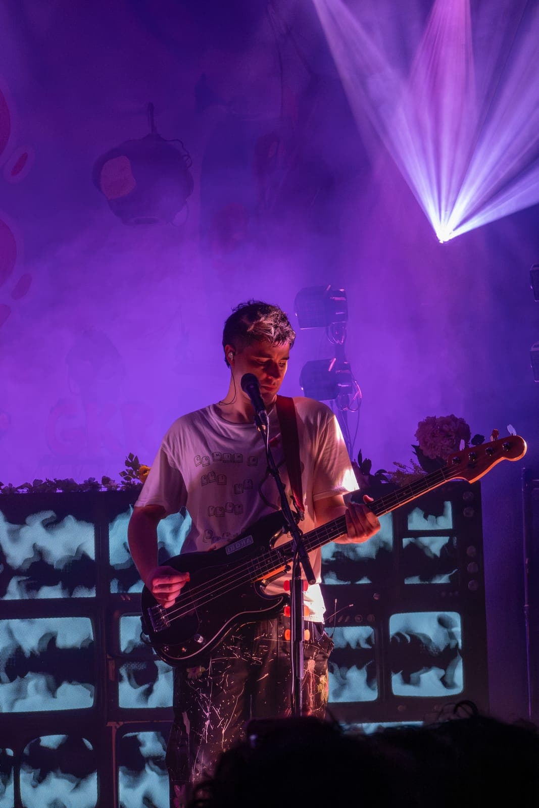 Good Kid's bassist plays in front of a wall of TV monitors under purple haze at Danforth Music Hall in Toronto