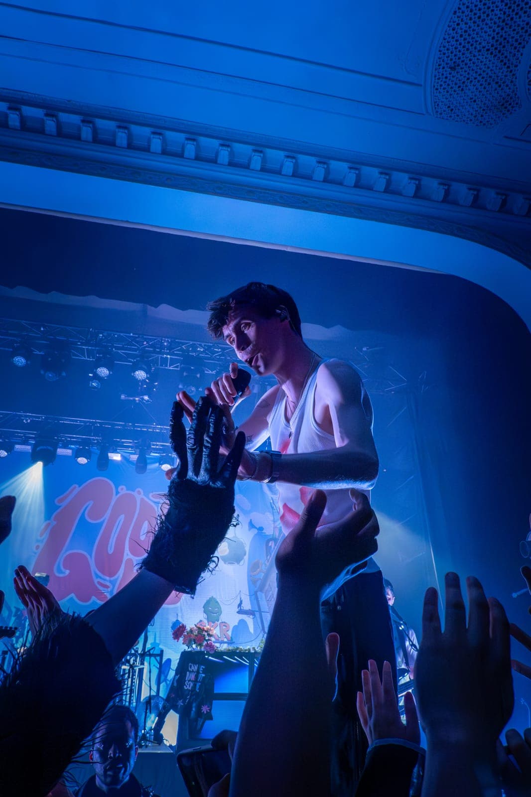 Good Kid's singer reaches down to fans' outstretched hands under blue light at Danforth Music Hall in Toronto