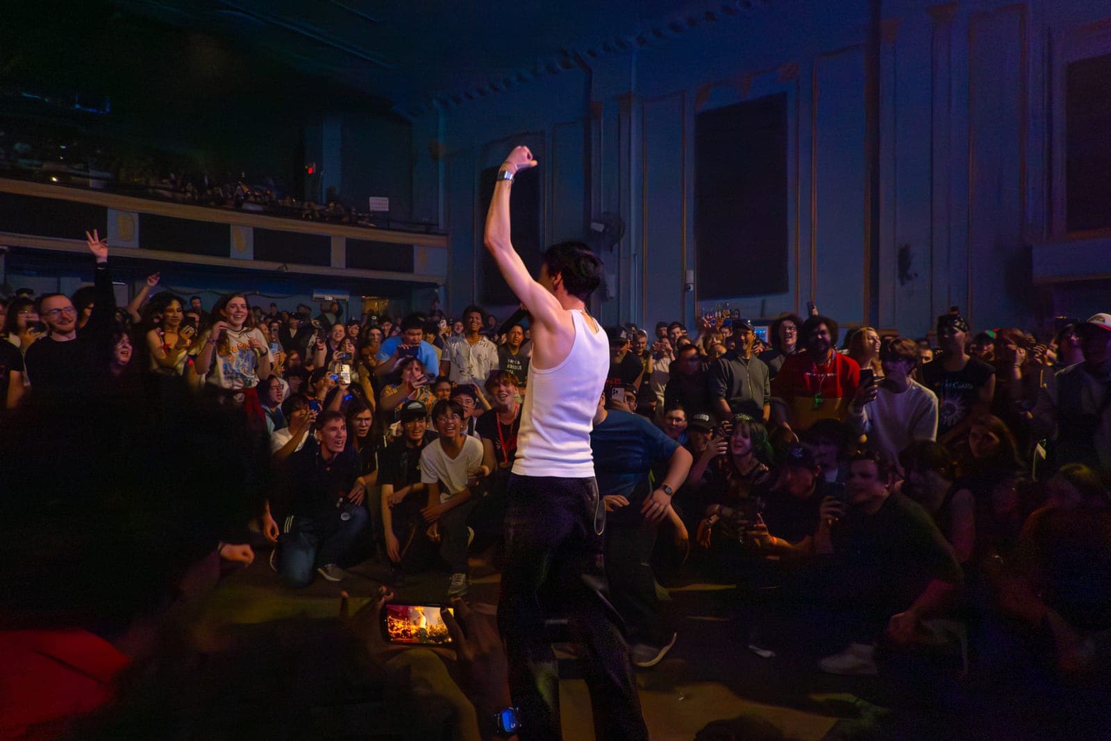 Good Kid's singer raises a fist facing a crouched crowd from a lowered stage at Danforth Music Hall in Toronto
