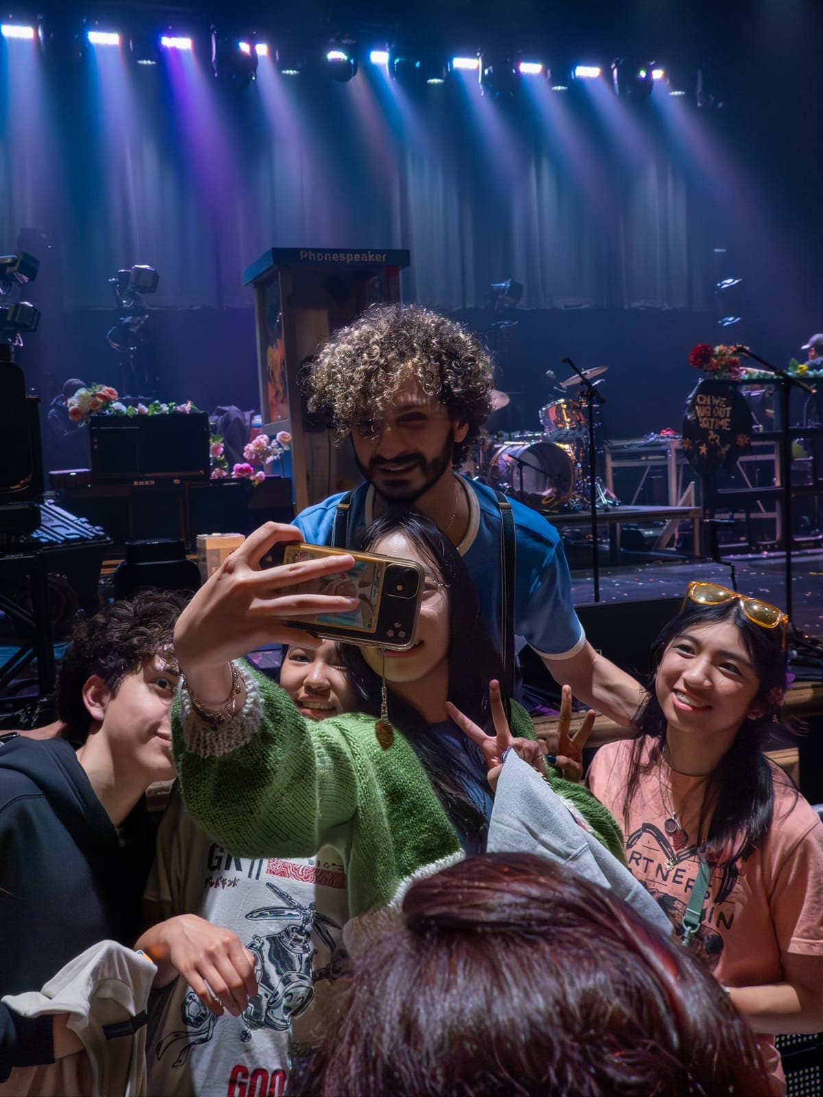 A member of Good Kid takes a selfie with fans on the flower-strewn stage after the show at Danforth Music Hall, Toronto