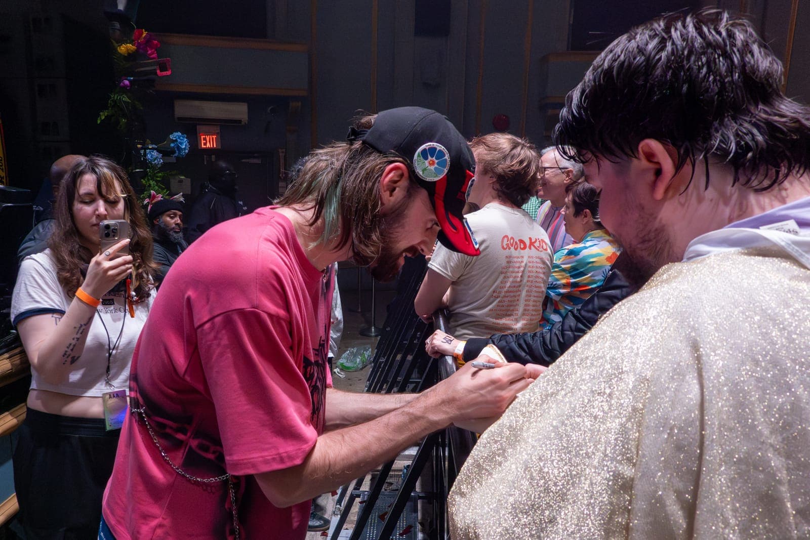 A member of Good Kid signs autographs for fans at the barricade after the show at Danforth Music Hall in Toronto