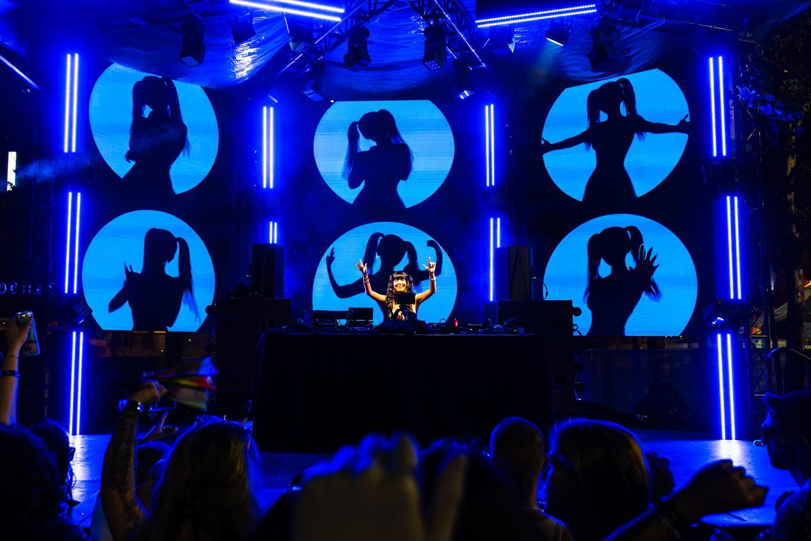Youna throws up her arms behind the decks as six circular screens loop her silhouette in deep blue at Green Space Festival in Toronto.