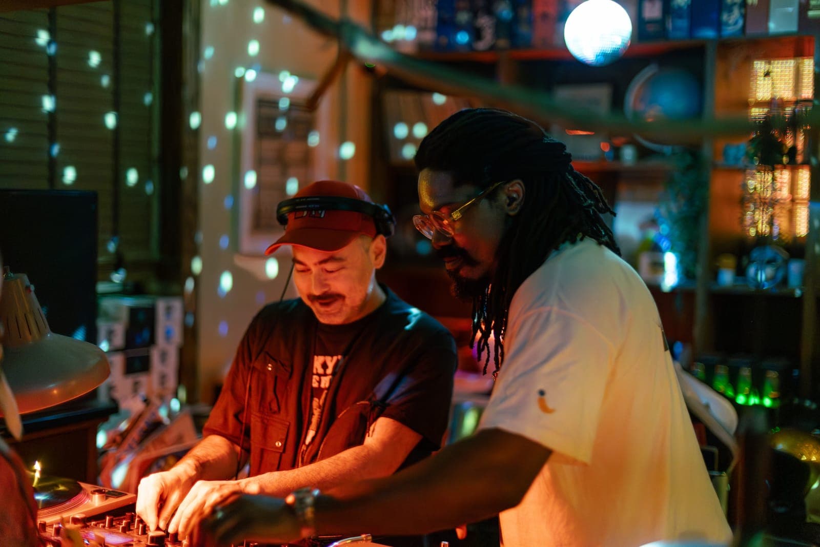 DJs Do Not Push and Kiinjo grin side by side at the turntables under disco-ball speckles at 915 Dupont in Toronto