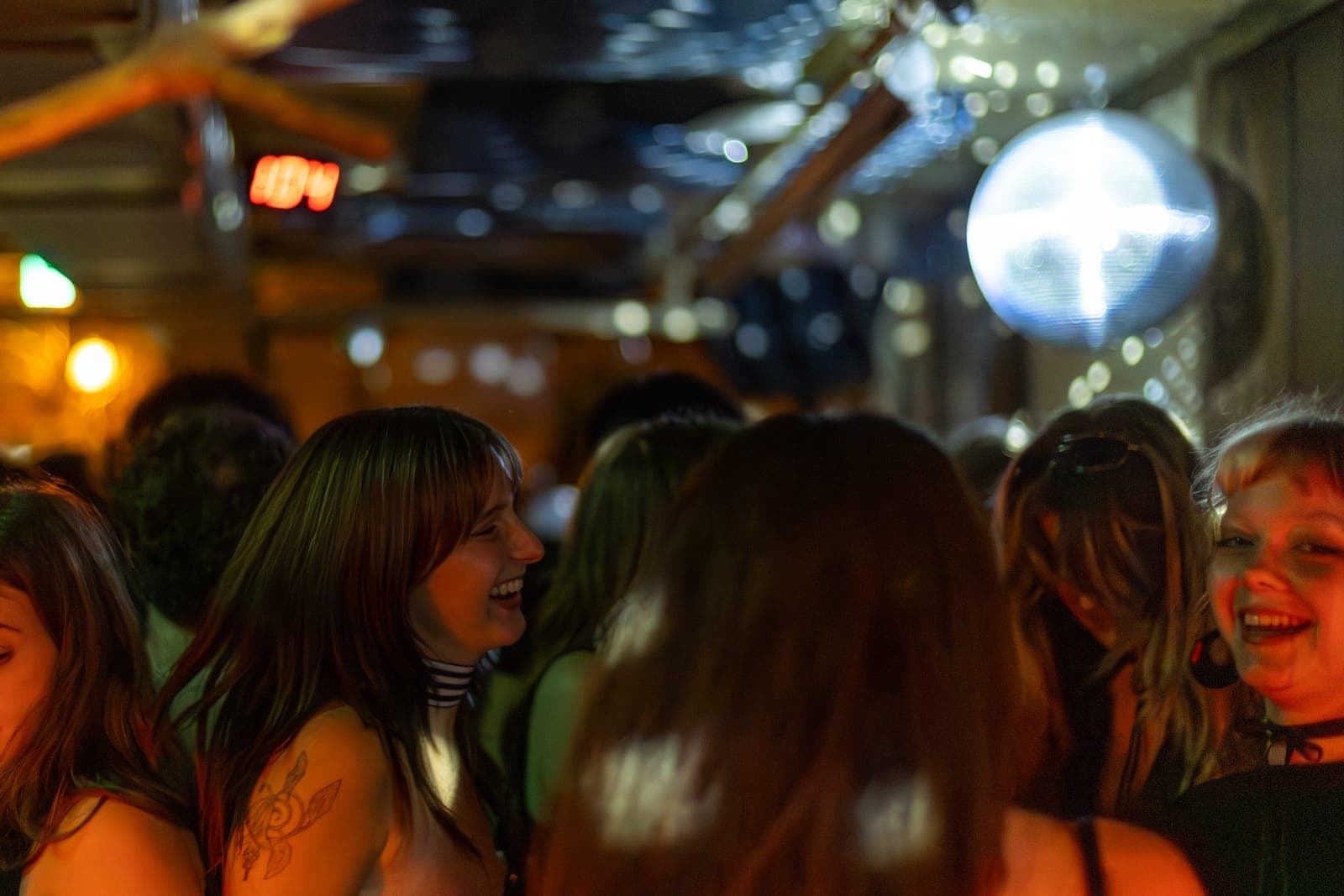 A dancer laughs on the crowded floor beneath a glittering disco ball at 915 Dupont in Toronto