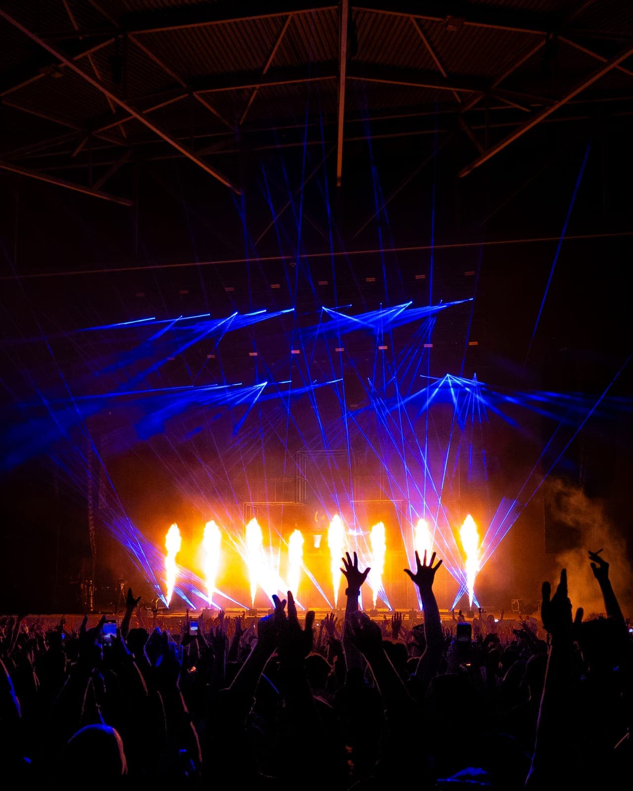 Flame jets and crisscrossing blue lasers light up Martin Garrix's set as fans raise their hands at RBC Amphitheatre in Toronto