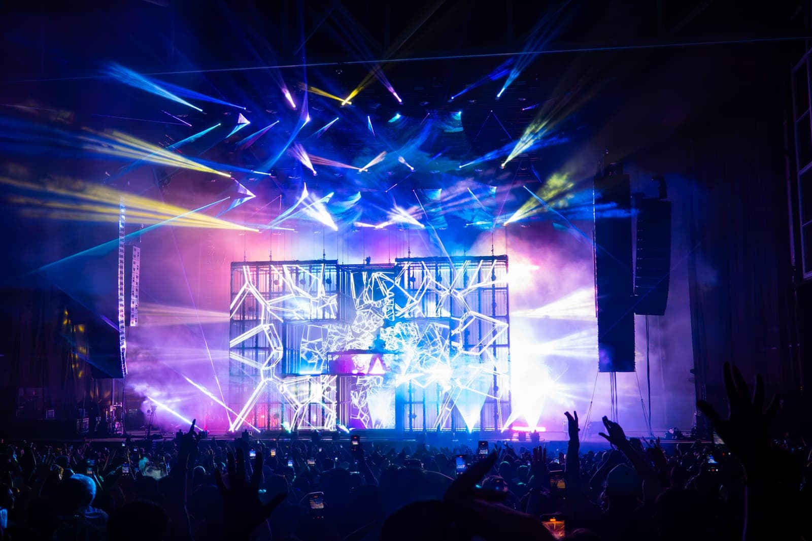 Blue and pink beams crisscross over Martin Garrix's stage visuals as the crowd films at RBC Amphitheatre, Toronto