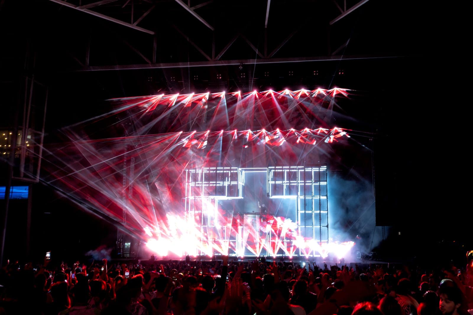 Red lasers rake across the grid-lit stage during Martin Garrix's set as the crowd dances at RBC Amphitheatre in Toronto