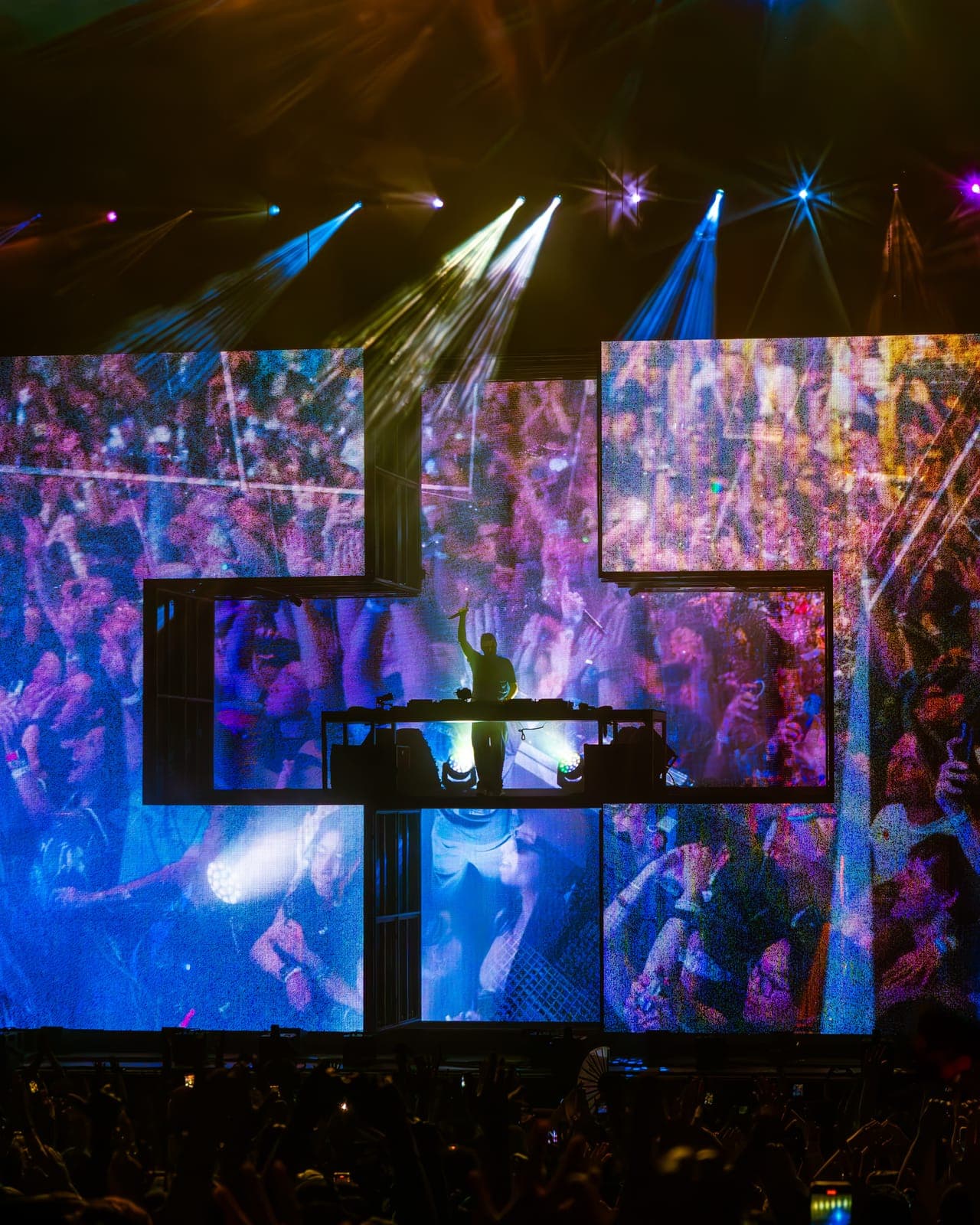 Martin Garrix silhouetted centre stage as screens show the crowd, under purple beams at RBC Amphitheatre, Toronto