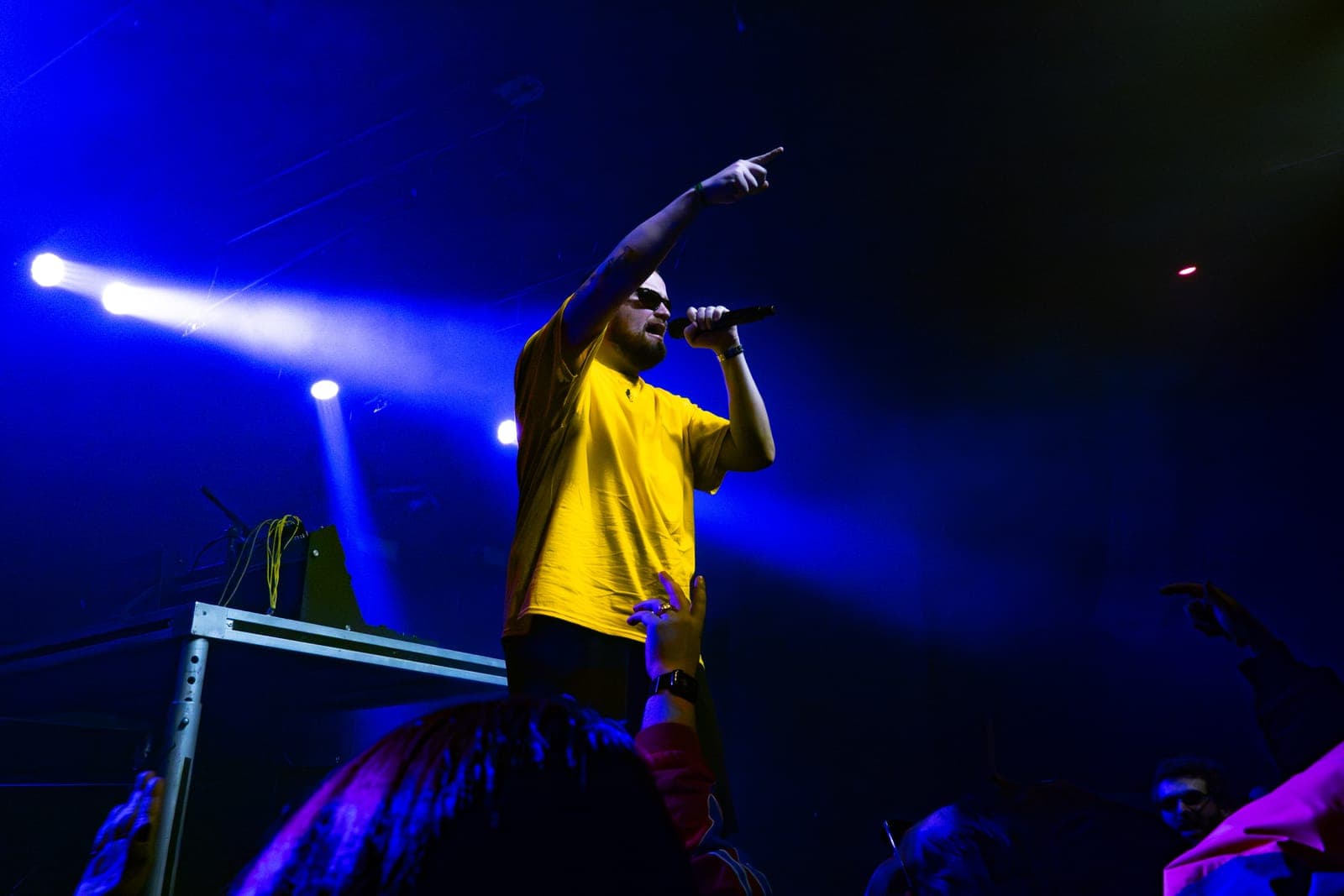 Myd points skyward with the mic as fans reach toward him under blue beams at The Mod Club in Toronto