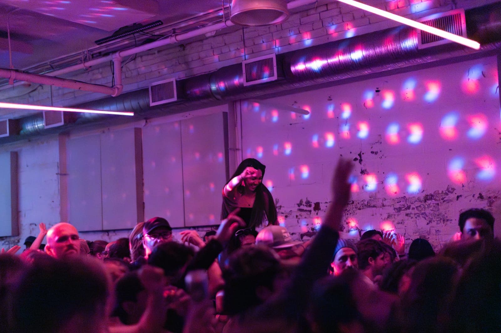 A fan rides on shoulders above the crowd in the industrial room at the Sapporo Live night at Standard Time, Toronto