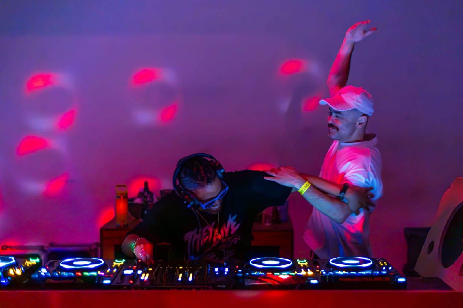 Felix Da Housecat and Kiinjo hype the crowd from behind the decks in pink light at Standard Time in Toronto