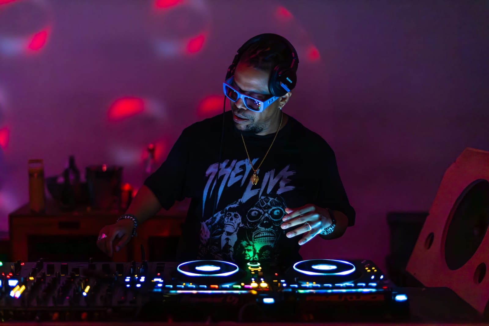 Felix Da Housecat DJs in blue sunglasses and a 'They Live' tee under pink light at Standard Time in Toronto