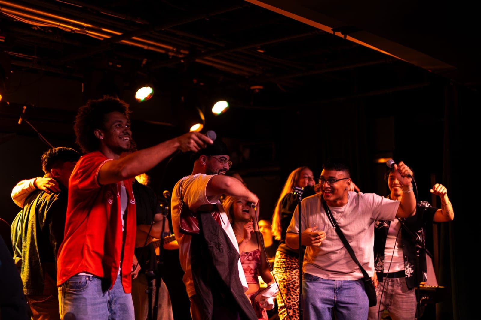 A Takes a Village vocalist points to the crowd as fellow singers line the stage at The Drake Underground in Toronto