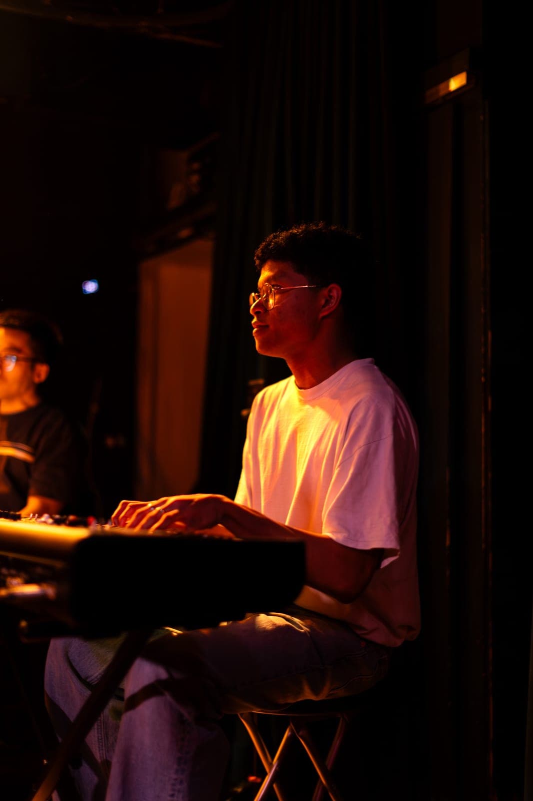 A Takes a Village keyboardist plays in profile under warm light at The Drake Underground in Toronto