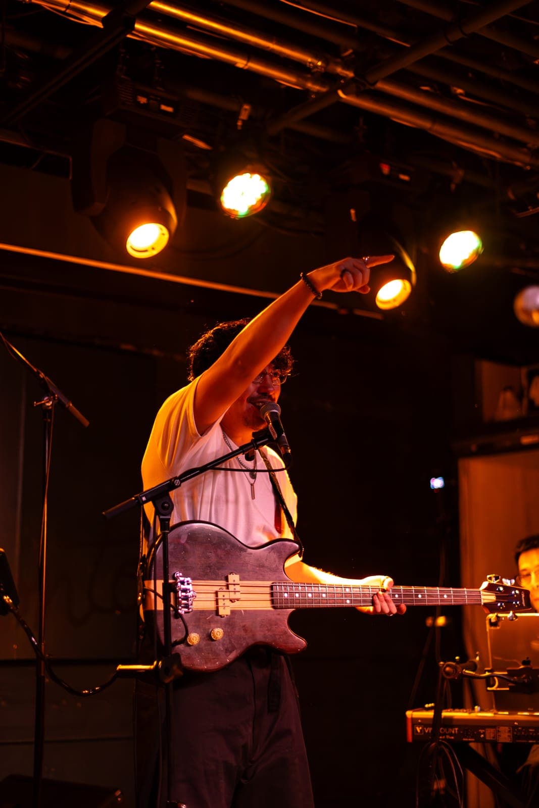 A Takes a Village bassist points skyward while playing and singing at The Drake Underground in Toronto