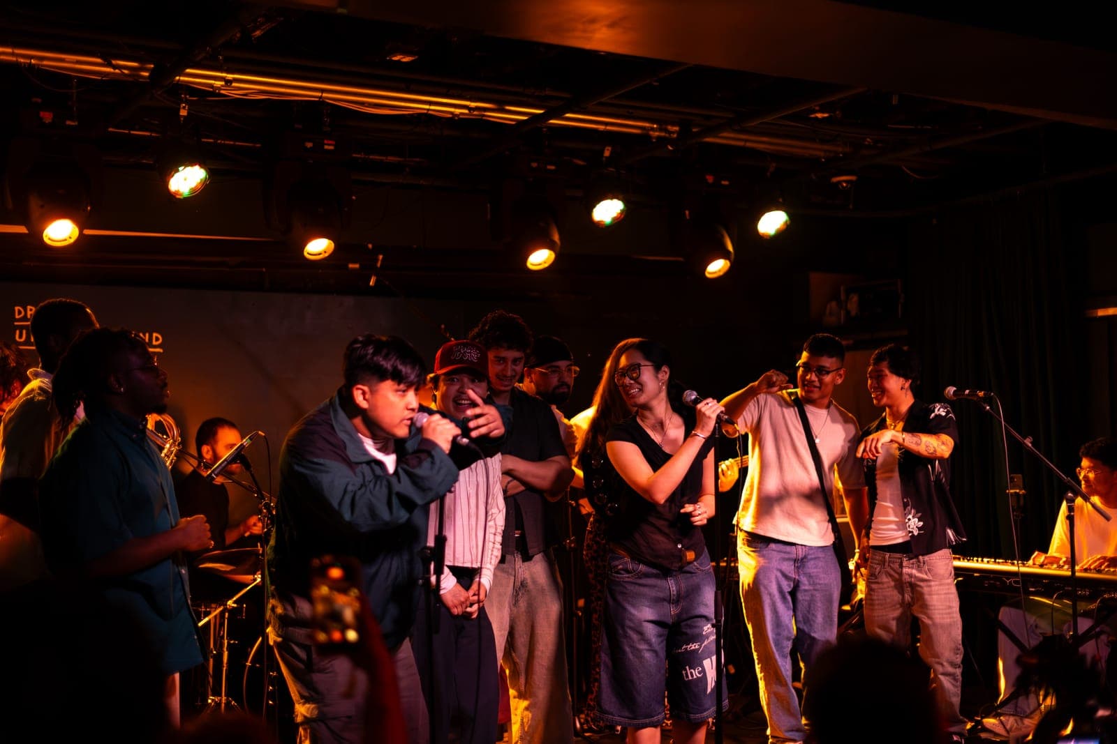 The Takes a Village singers gather along the front of the stage trading mics at The Drake Underground in Toronto