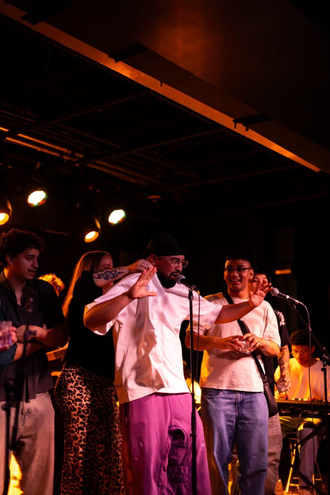 A Takes a Village vocalist sings surrounded by the collective at their Potluck Volume 1 release at The Drake Underground, Toronto