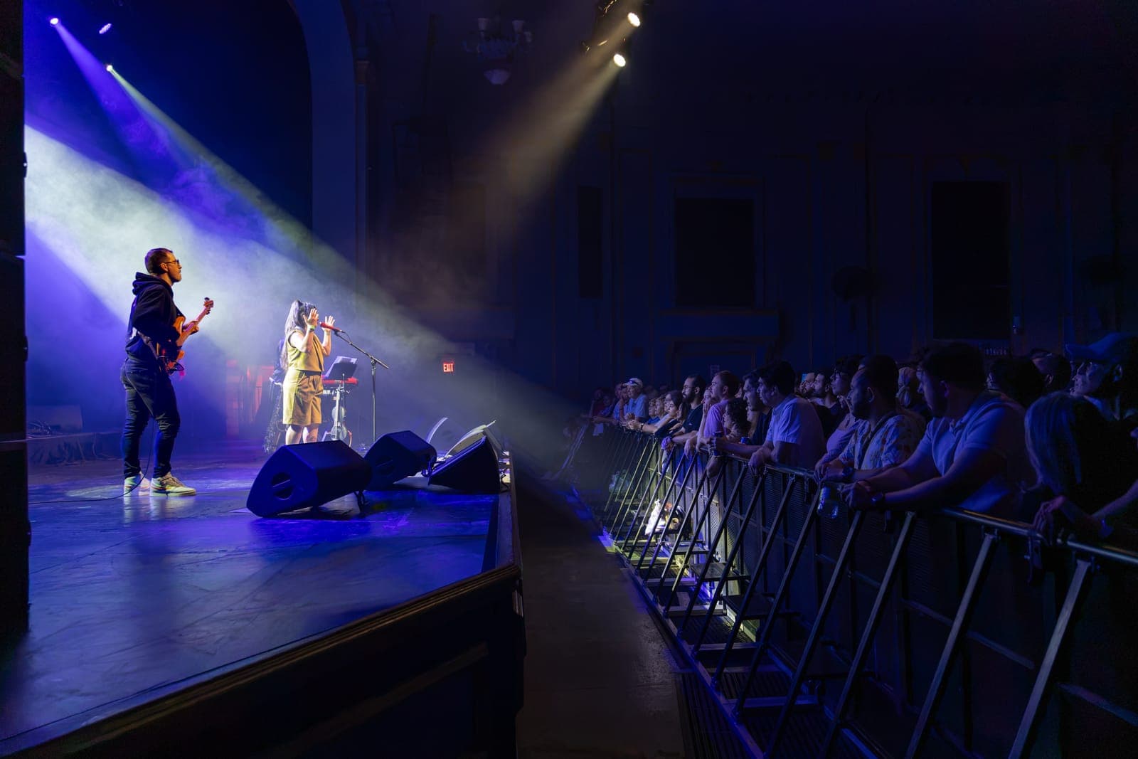Maya Killtron sings into her mic beside her bassist as a shaft of light crosses to fans lining the barricade at Danforth Music Hall