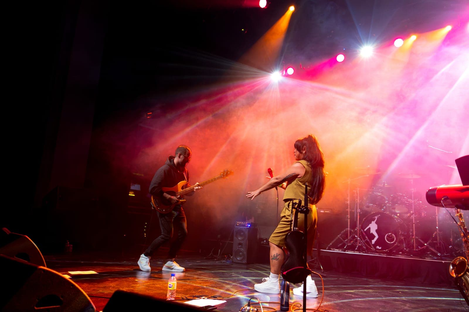 Maya Killtron and her bassist face off mid-song in a blaze of orange and pink light