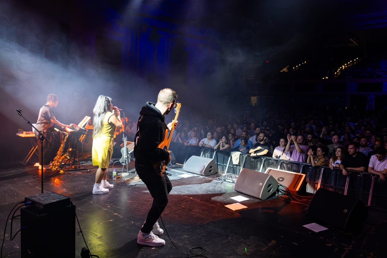 Seen from behind the bassist, Maya Killtron sings to a sold-out Danforth Music Hall as her saxophonist plays keys