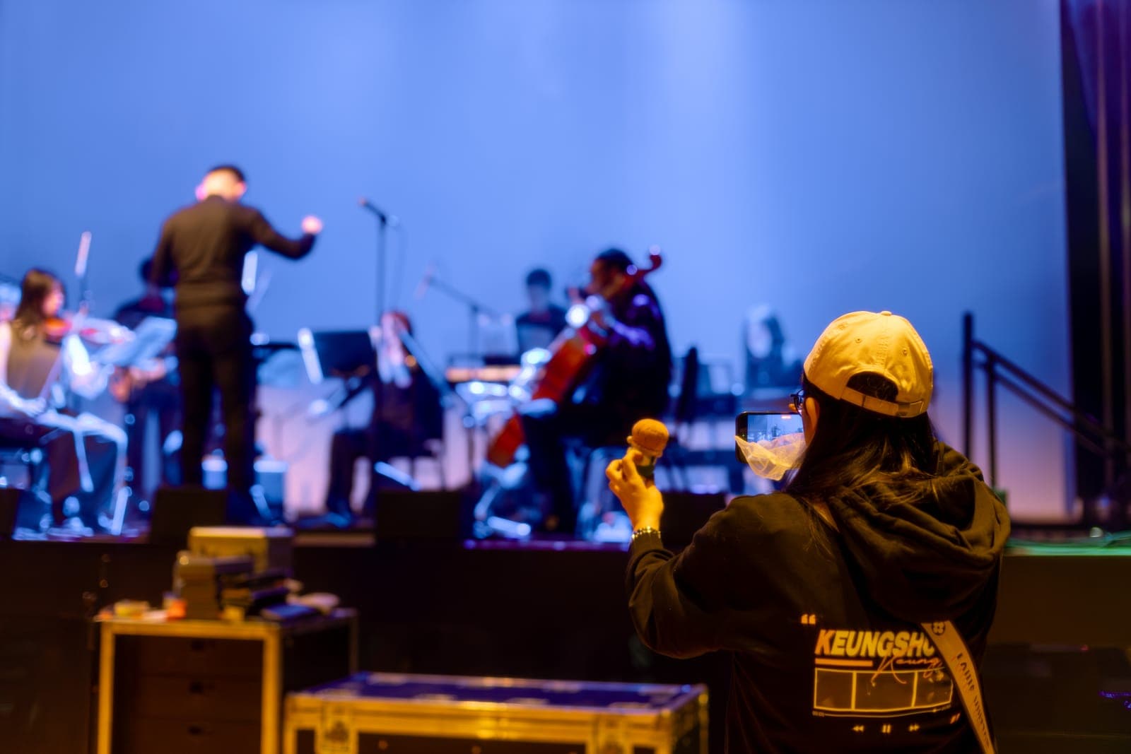 A fan in a Keung To hoodie films the Toronto Pops Orchestra on her phone at TD Music Hall in Toronto
