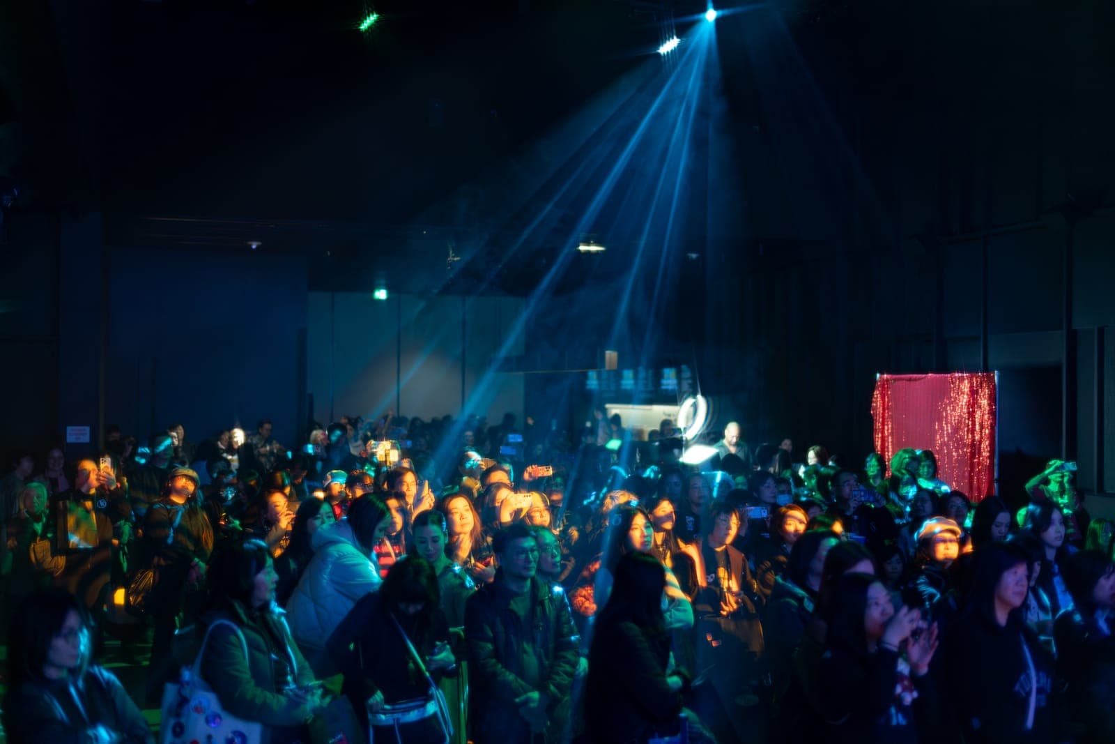 Fans fill the darkened hall amid blue spotlight beams at the Keung To fan event at TD Music Hall in Toronto