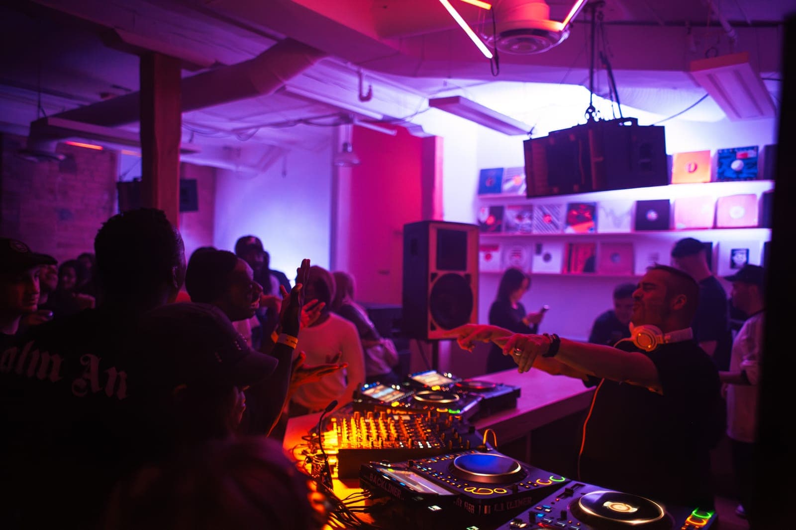 Todd Edwards points to the crowd from behind the decks in the vinyl-lined room at Rhythm in Toronto